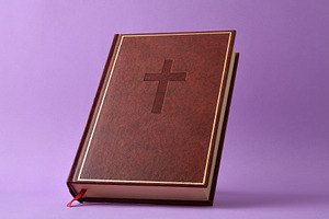 Bible with leather cover and cross engraved isolated on purple, an Arts & Entertainment Photo by Davizro's Market