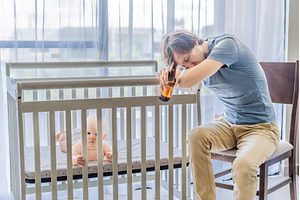 Sad father sitting beside his baby, a Person Photo by Elizaveta Galitskaya