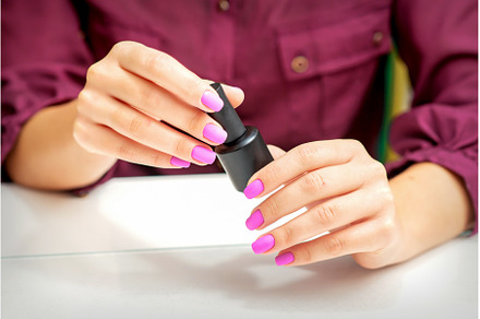 White woman holding nail polish, a Beauty & Fashion Photo by okskukuruza
