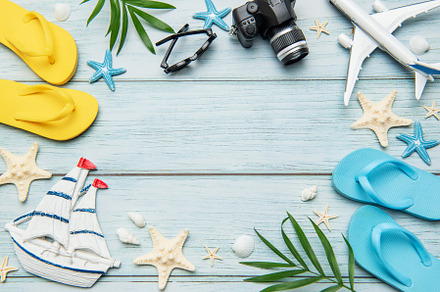 Summer vacation accessories forming a frame on wooden background