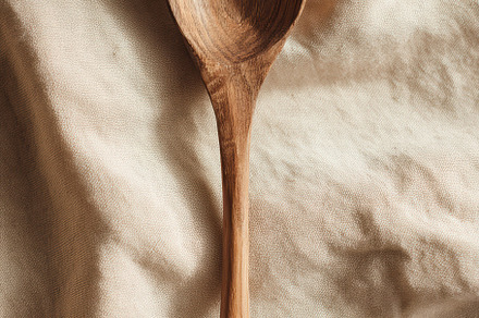 Wooden spoon on beige fabric, a Photo by Virgo Studio