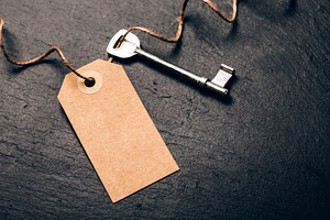 Key and empty tag on dark stone, a Business Photo by Anna Efetova