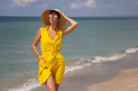 young fashionable woman in a yellow hat dress and sun glasses is posing on beac, a Person Photo by SaulichPhoto