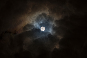 Full moon in a dark cloudy sky