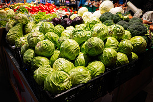 Fresh organic green cabbages displayed at a farmer's market produce stall, a Photo by AS photostudio