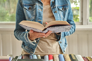 Hands holding open book in bookstore, a Person Photo by BOOCYS