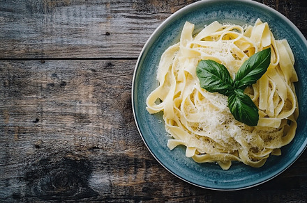 Creamy parmesan pasta garnished with fresh basil served on rustic wooden table, a Food & Drink Photo by AlyaAnd