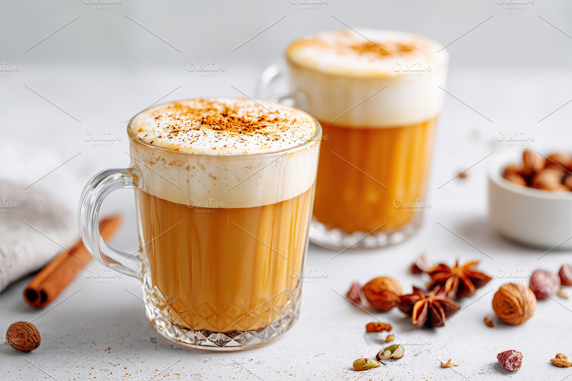 Delicious spiced coffee served in clear mugs with frothy milk on a light backgr, a Food & Drink Photo by AlyaAnd