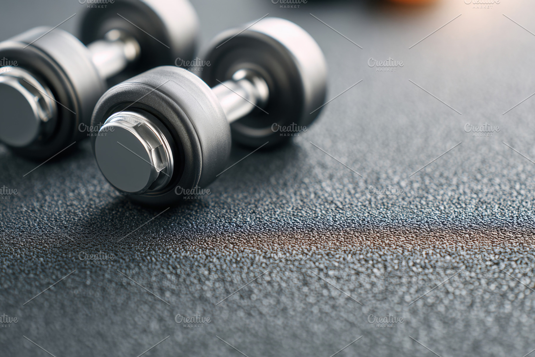 Shiny metal dumbbells on textured surface, a Sports & Recreation Photo by AlyaAnd