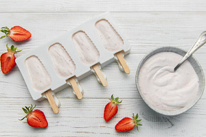 Homemade strawberry yogurt popsicles chilling in mold, a Food & Drink Photo by Olena Rudo