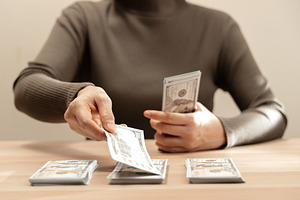 Sorting cash money into piles on a wooden table. Personal financ, a Photo by salmon.black