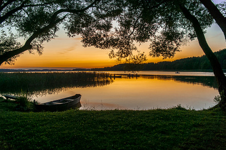 Sunset and old wooden fishing boat featuring sky, dusk, and summer, a Nature Photo by verkelis