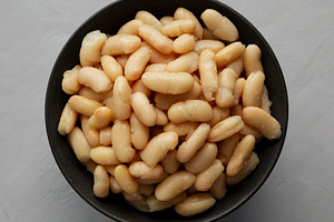 Organic Cannellini Beans in a Bowl, top view. Flat lay, overhead, a Food & Drink Photo by LiudmylaChuhunova