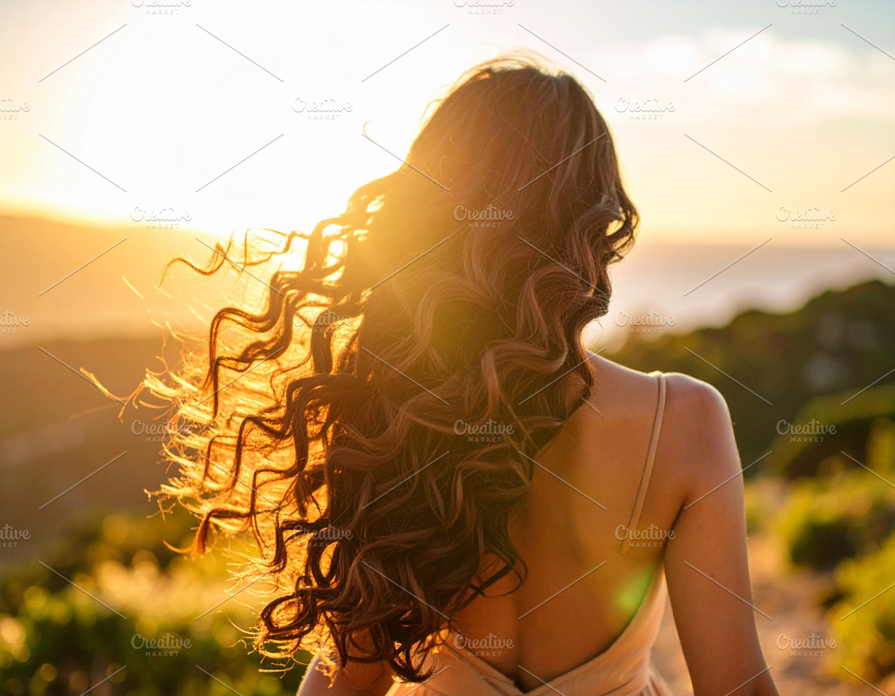 Young woman at nature with voluminous curly hair captured from b, a Health & Medical Photo by DanFLCreativo