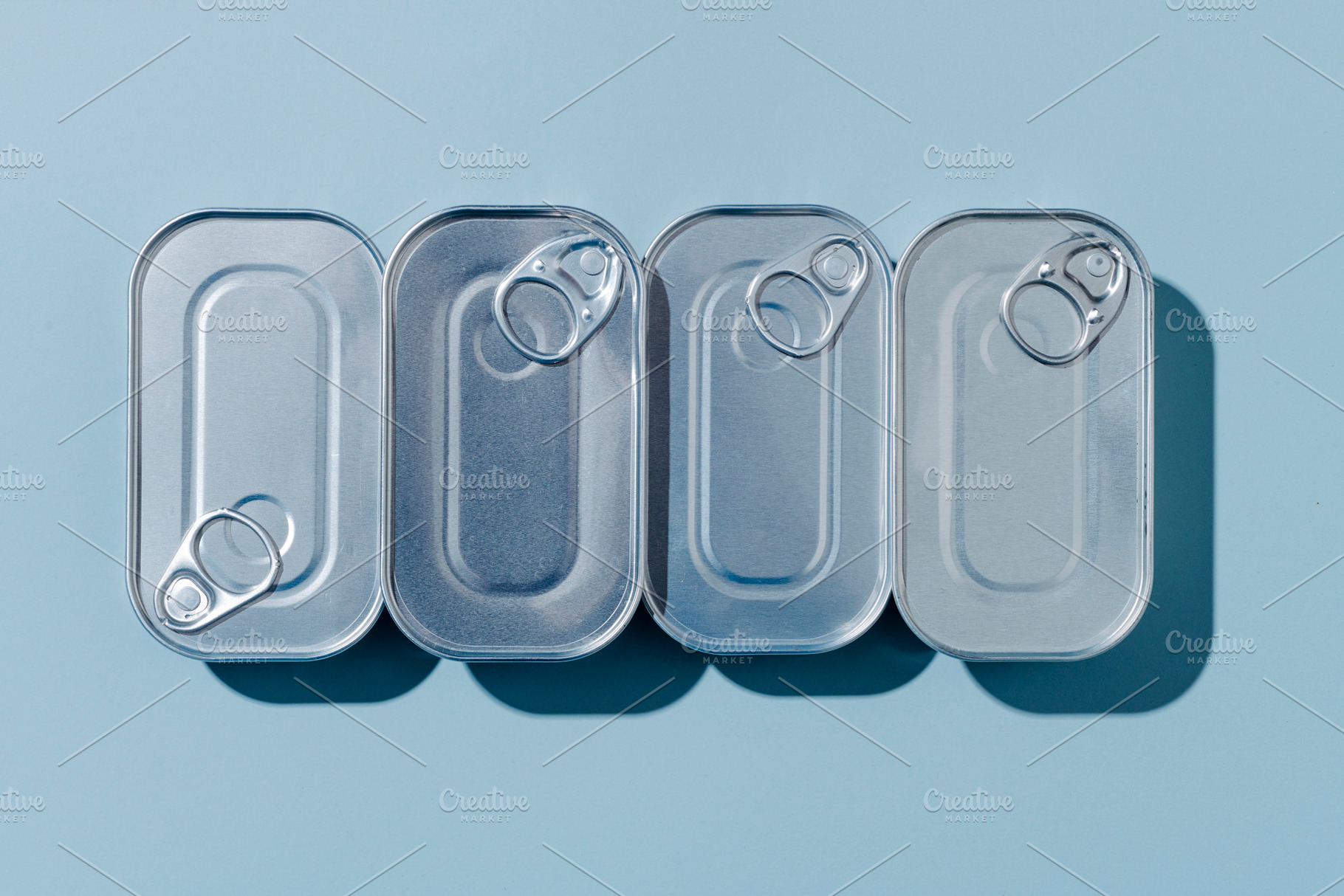 four unopened tin cans of canned food, a Photo by Nito