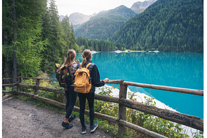 Two women with backpacks standing, a Person Photo by den-belitsky