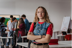 Confident teen student standing in, a School & Education Photo by HalfPoint
