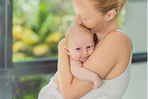 Mother gently hugging her baby at, a Person Photo by Elizaveta Galitskaya