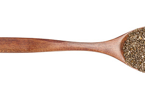 Chia seeds in a brown wooden spoon on isolated background, a Food & Drink Photo by ndanko