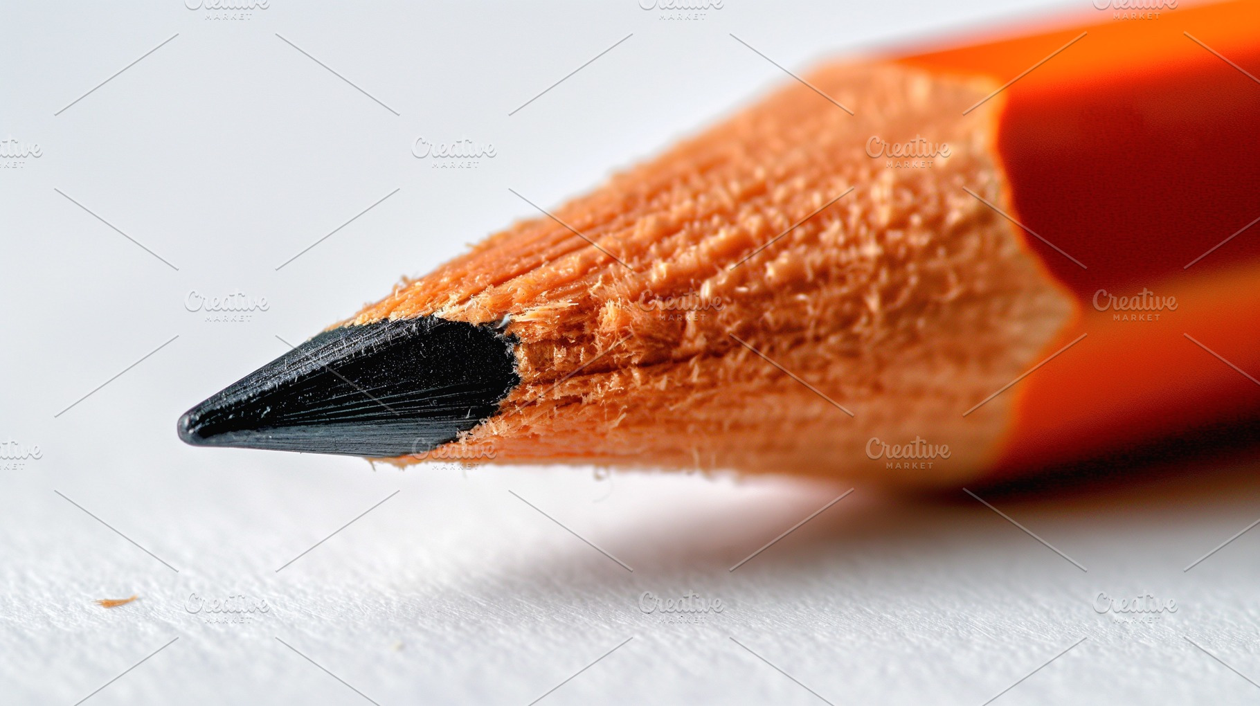 Close-up of an orange-colored pencil with a sharp black tip, showcasing intrica, a Background Photo by ImageMir