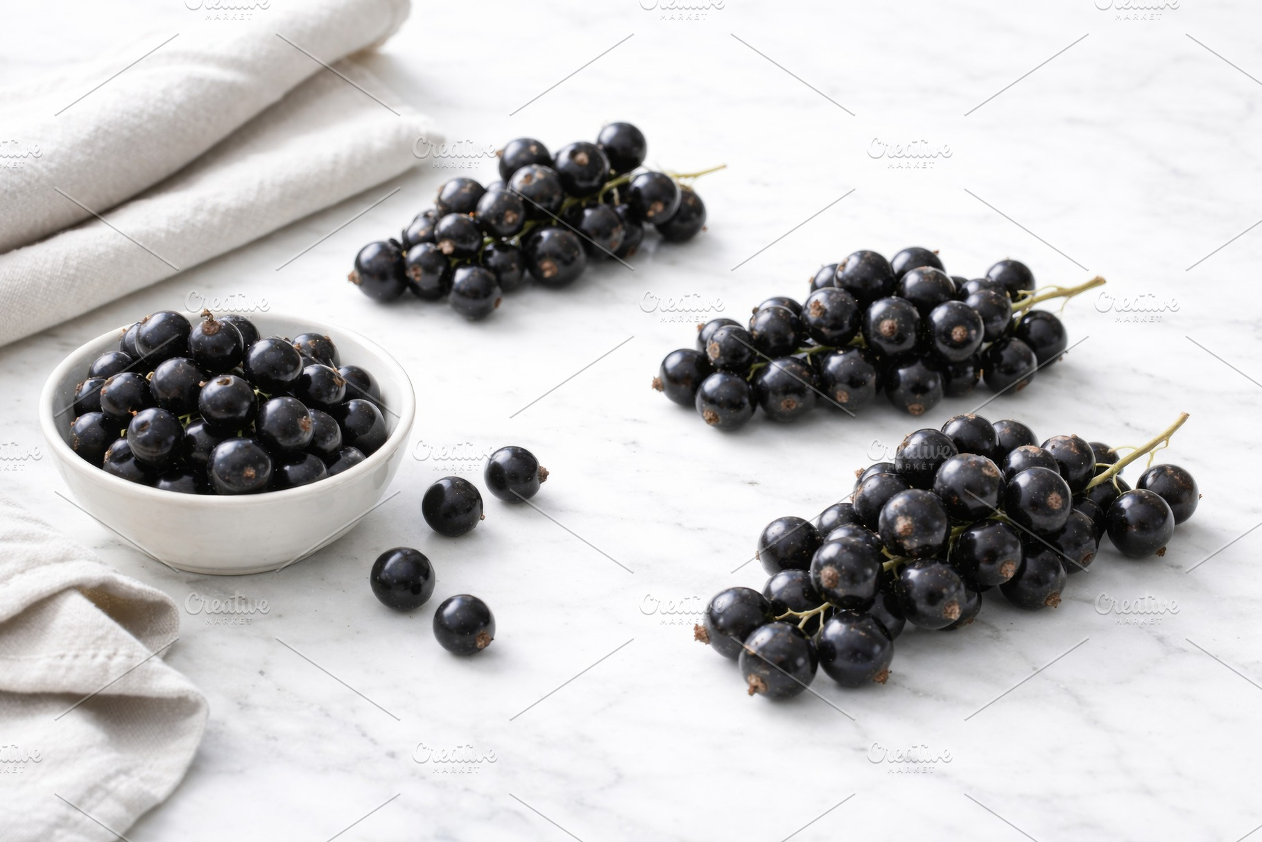 Black currant berries arranged on wh, a Photo by Dvoevnore photos