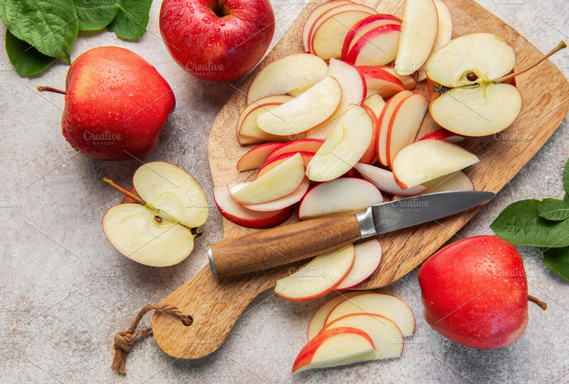 Red apples slicing on wooden cutting board, a Food & Drink Photo by Olena Rudo