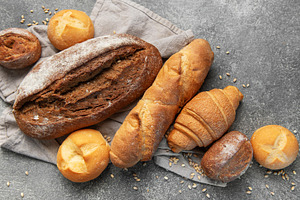 Freshly baked bread assortment on rustic grey background, a Food & Drink Photo by Olena Rudo