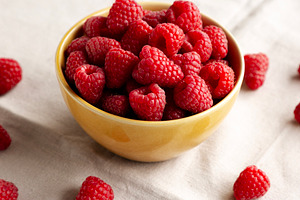 Organic Raw Red Raspberries in a Bowl, side view., a Food & Drink Photo by LiudmylaChuhunova