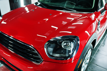 Headlights and hood of sport red car in garage., a Transportation Photo by AS photostudio