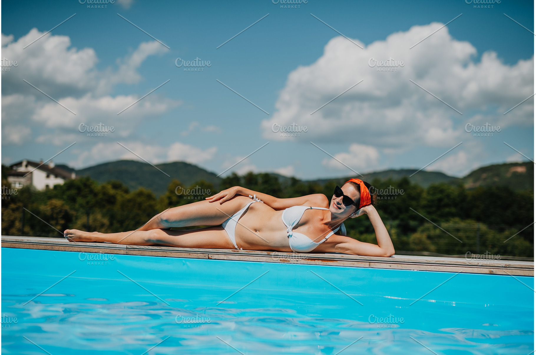 Young woman lying by the on edge of, a Person Photo by HalfPoint