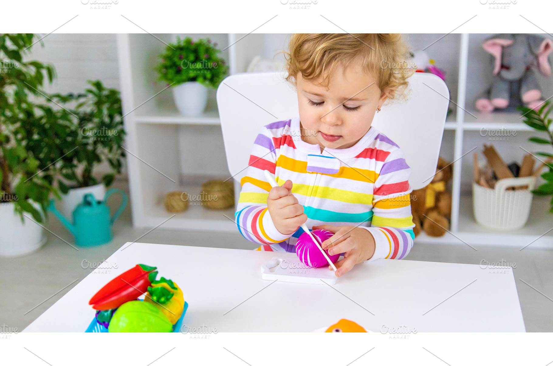 Child plays kitchen and food toys, a Person Photo by yanadjana