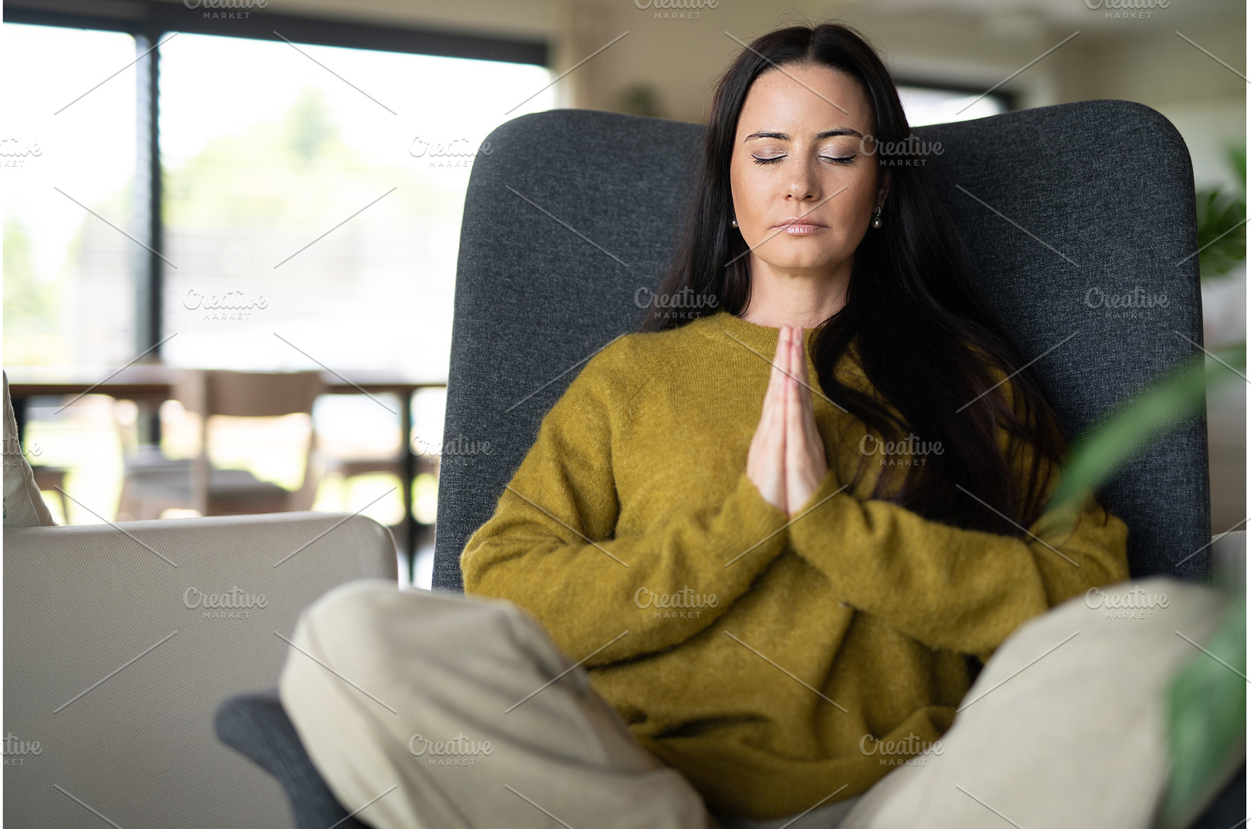 Woman meditating with hands in, a Person Photo by HalfPoint