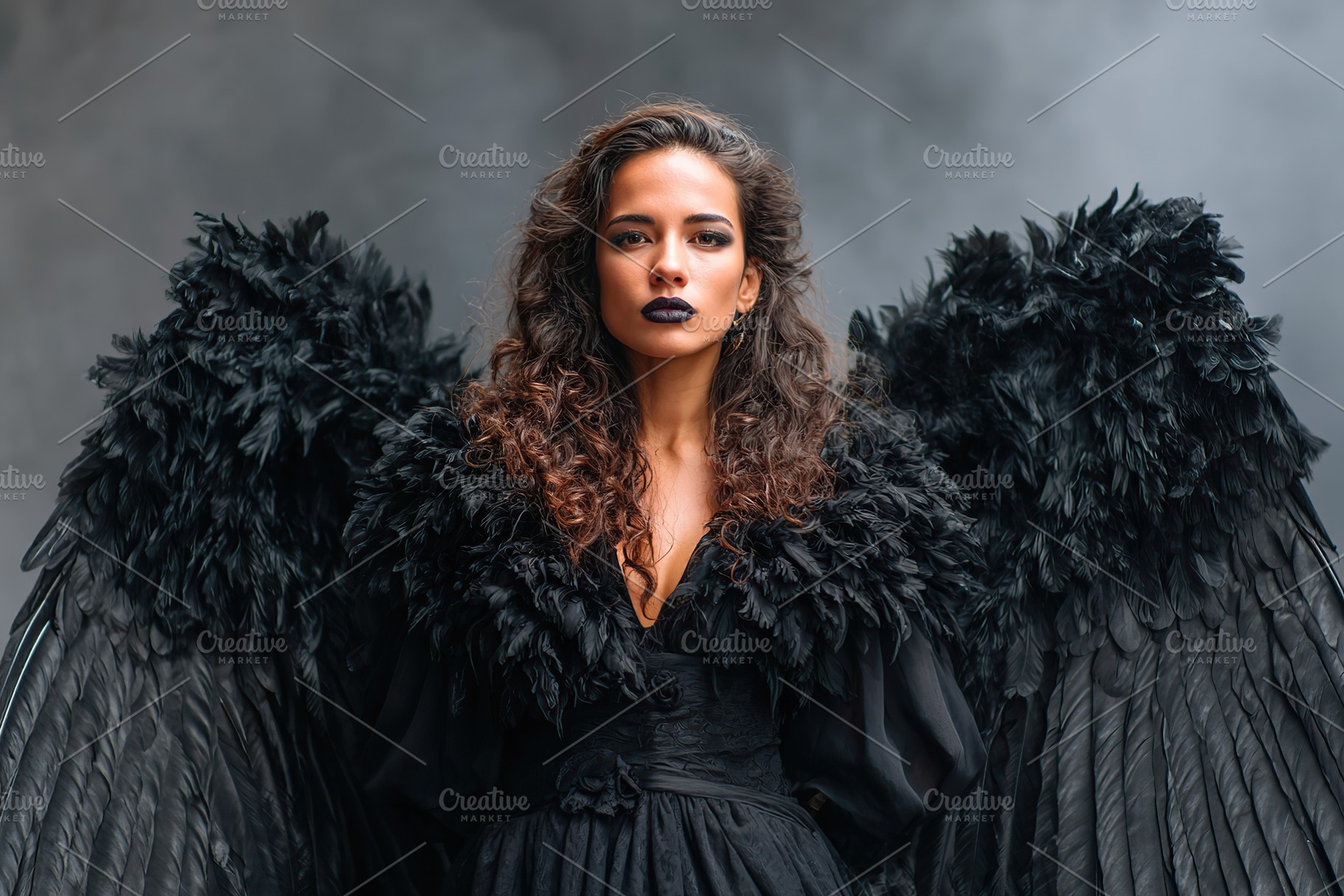 Model poses dramatically in black feathered wings against a smoky backdrop duri, a Photo by AlyaAnd
