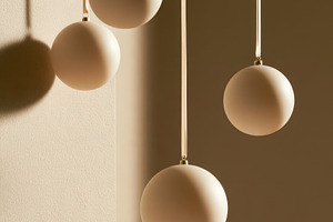 Minimalist beige Christmas baubles hanging on ribbons with drama, a Food & Drink Photo by José Manuel Gelpi