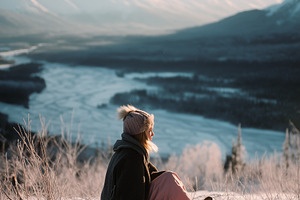 Girl Sitting in Snow Above River, a Person Photo by k.tay