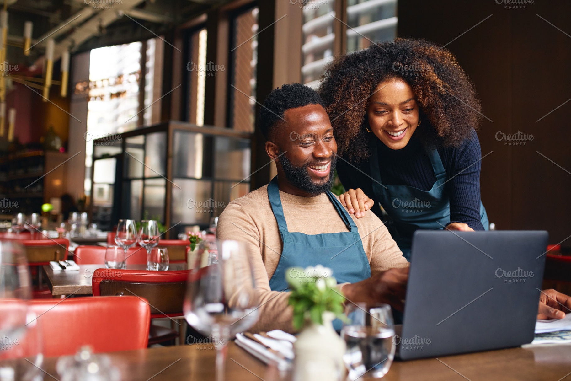 Small business owners using laptop in restaurant, a Person Photo by Southworks
