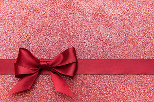 Red glitter background with decorative ribbon bow, a Holiday Photo by Olena Rudo