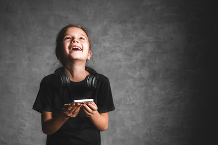 Little girl with headphones and phon