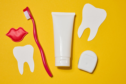 Red toothbrush, white tube of toothpaste, red decorative lips, d