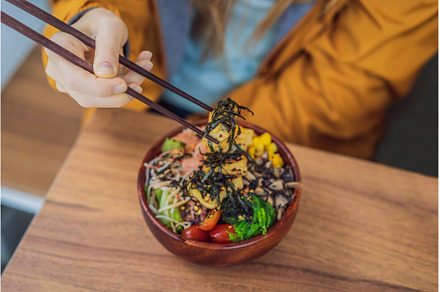 Woman eating Raw Organic Poke Bowl, a Food & Drink Photo by Elizaveta Galitskaya
