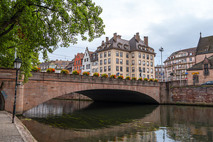 Stone bridge with flowers crossing the Ill river Strasbourg, Fra, an Architecture Photo by GoodGoods