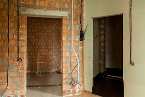Apartment interior under renovation with exposed brick walls, an Industrial Photo by Photostock