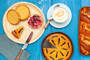 Delicious breakfast with cappuccino, cakes, rusks and jam on a blue wooden tabl, a Food & Drink Photo by Antonio Gravante Market