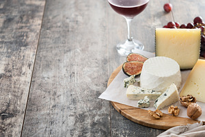 Board of different cheeses with nuts, figs and grapes, a Food & Drink Photo by etorres69