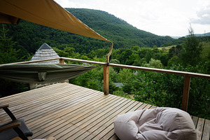 Scenic mountain deck with hammock and bean bag overlooking lush green landscape, a Photo by AS photostudio