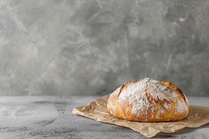 Freshly baked bread on grey background, a Food & Drink Photo by AlyaAnd