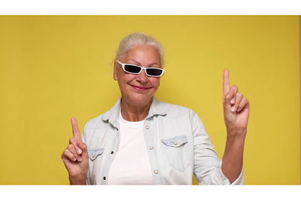 An elderly woman points her finger