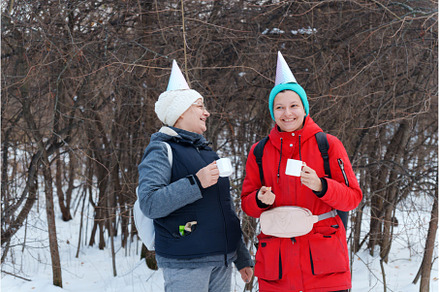 Two friends stand joyfully in a
