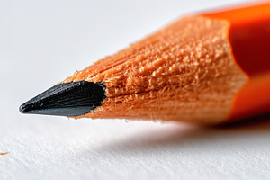 Close-up of an orange-colored pencil with a sharp black tip, showcasing intrica, a Background Photo by ImageMir