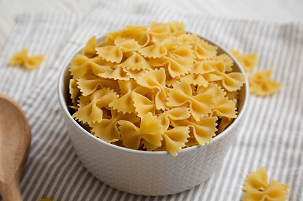 Dry Organic Farfalle Pasta in a Bowl on a white wooden backgroun, a Food & Drink Photo by LiudmylaChuhunova